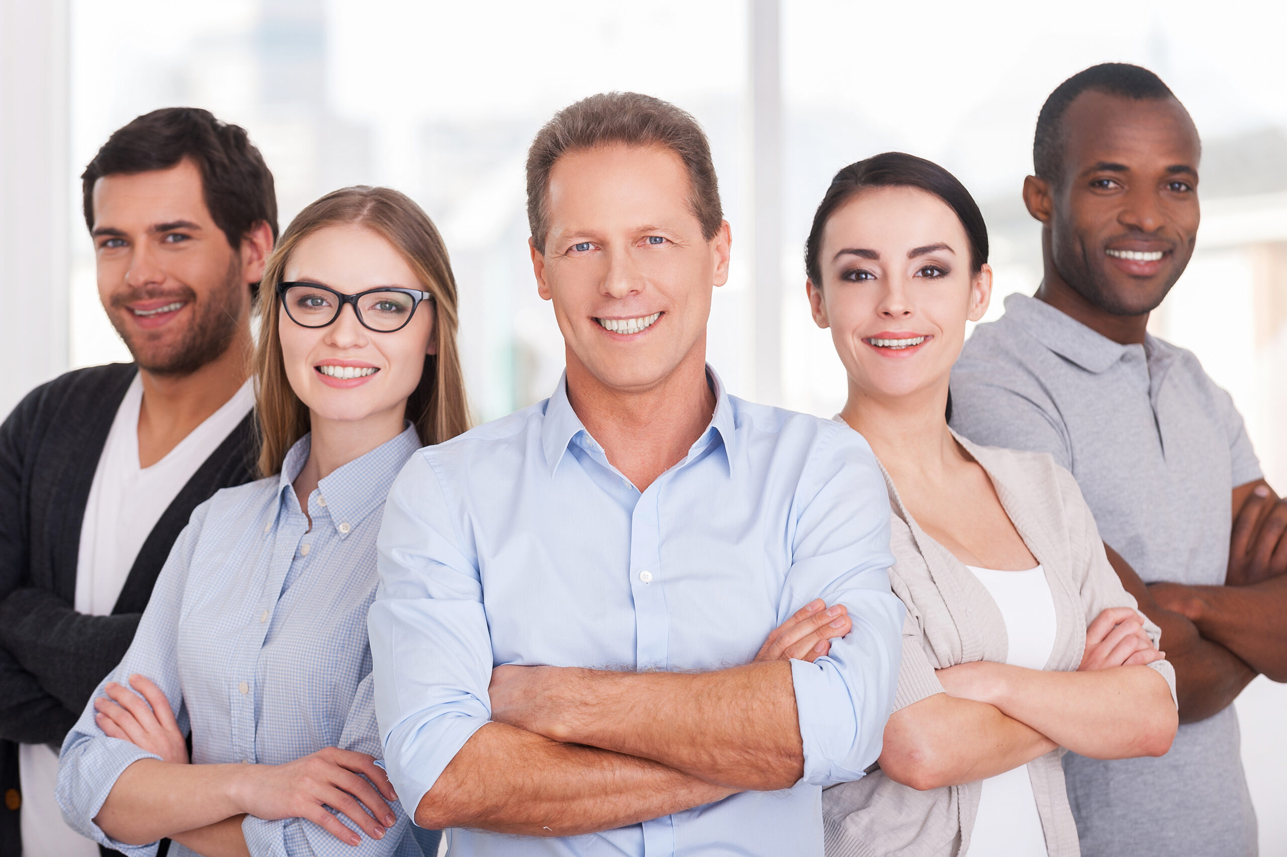 Confident business team. Group of cheerful business people in casual wear standing close to each other and keeping arms crossed